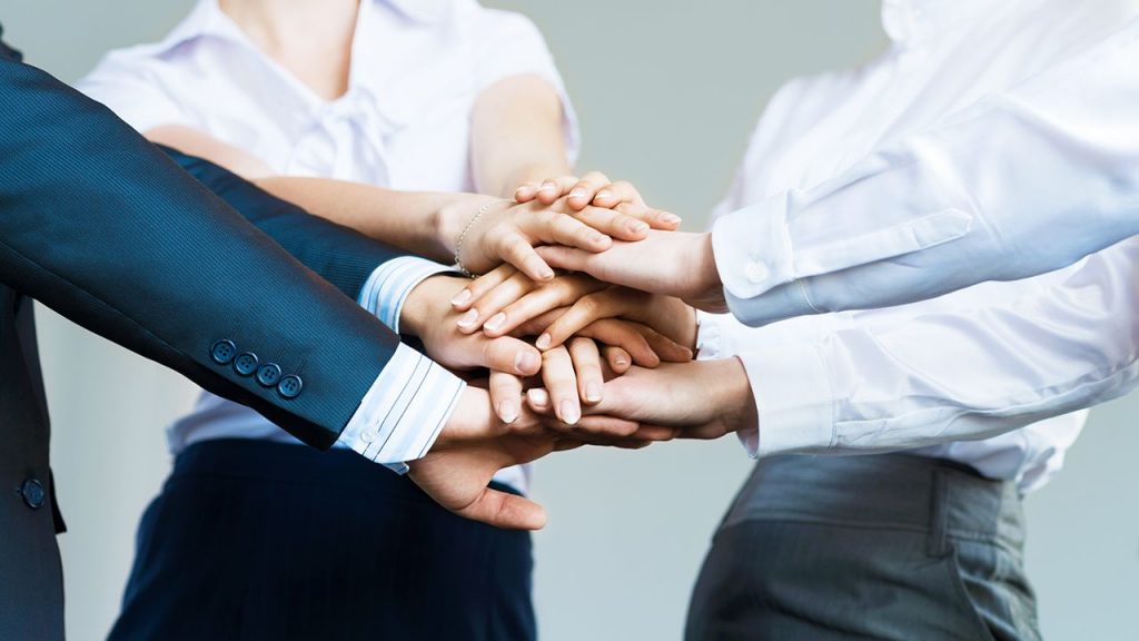 Humildad, tres empleados juntando sus manos